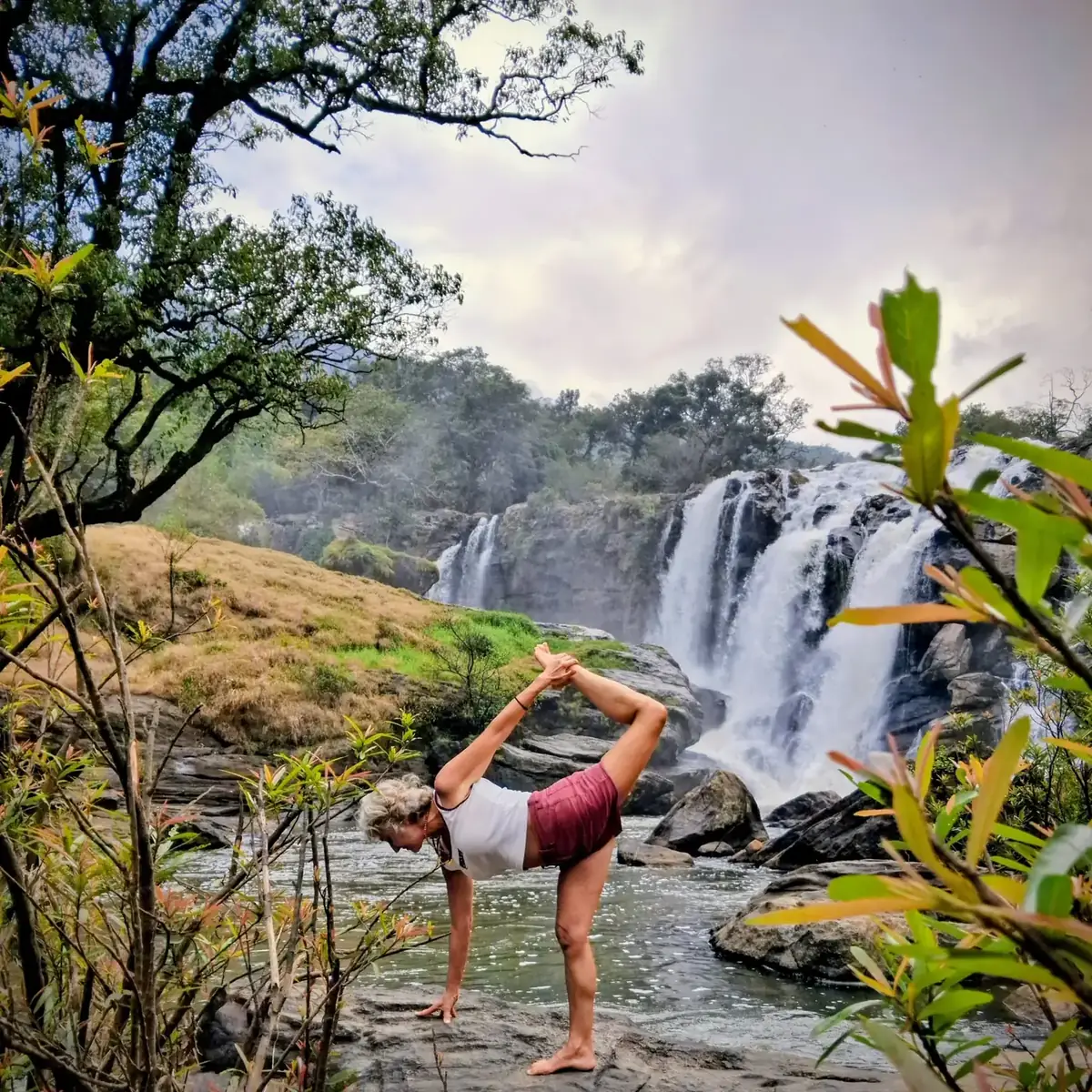 Posture du danseur devant une cascade, en Inde